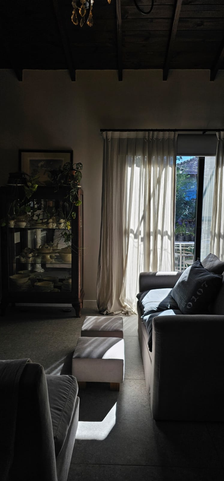 Cortinado de tela natural en living con sofá