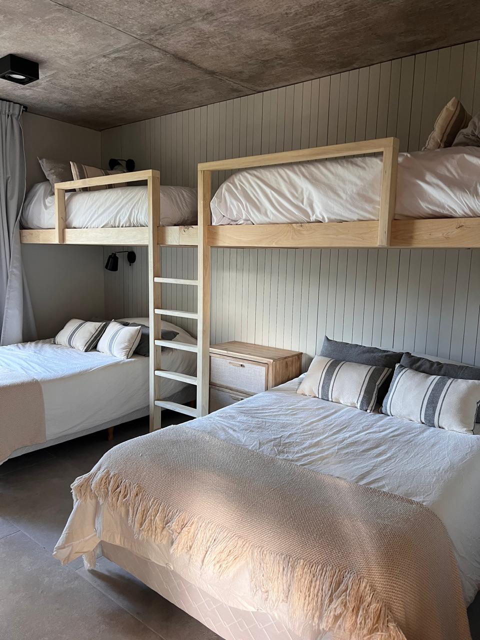 Dormitorio con cuchetas y cortina de tela gris a medida